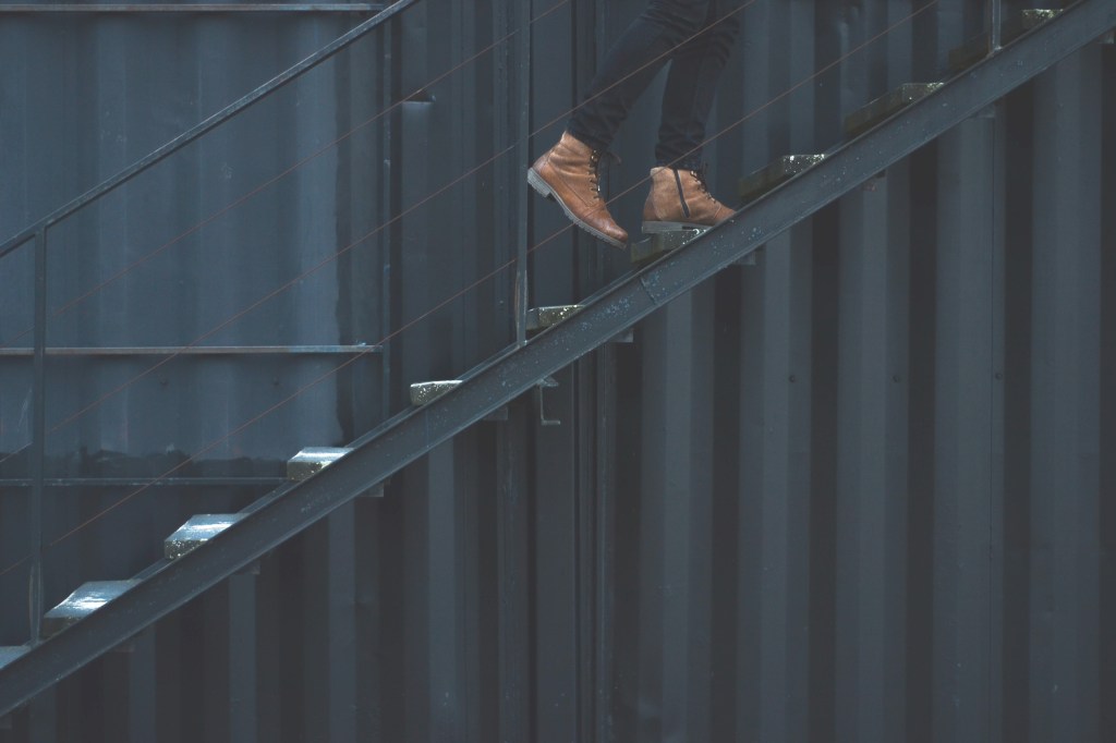 We see the bottom half of a pair of legs ascending a staircase